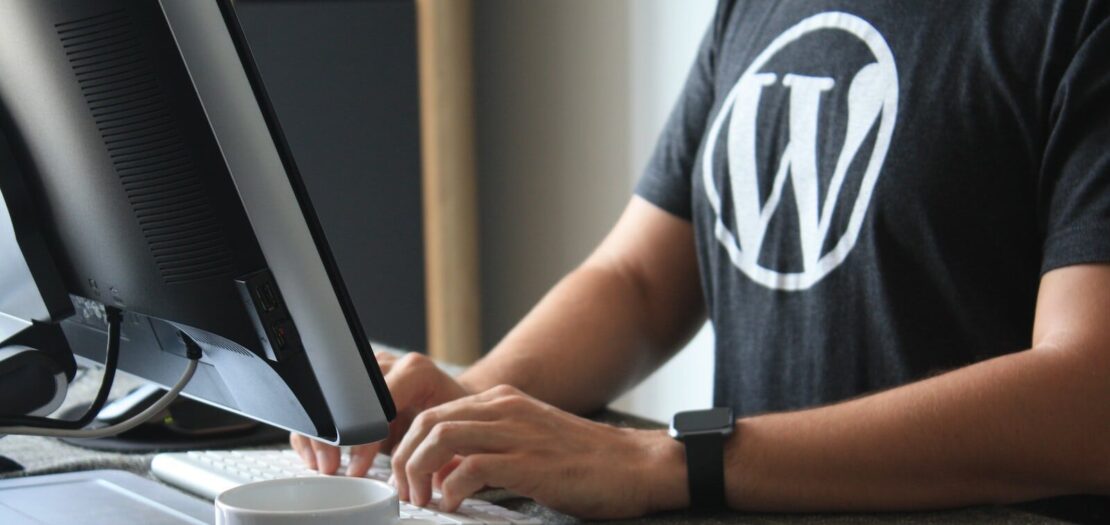 person in black and white t-shirt using computer