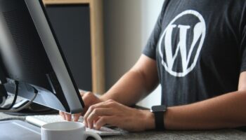 person in black and white t-shirt using computer