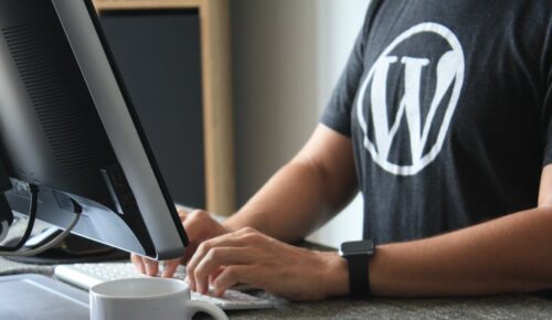 person in black and white t-shirt using computer