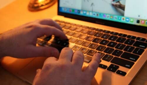 a pair of hands typing on a laptop keyboard